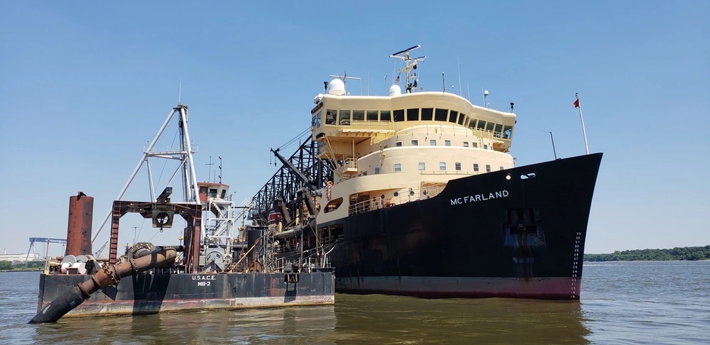 USACE deep-draft hopper dredge McFarland working beside its dredging plant on a federal navigation waterway