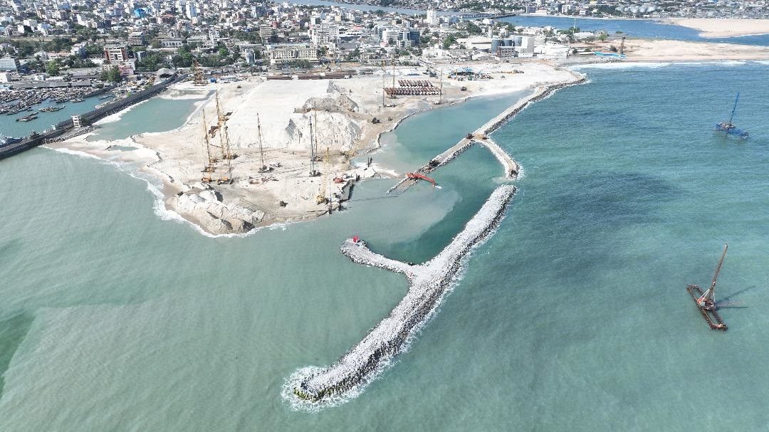 Aerial view of Terminal 5 marine works at Cotonou showing rock breakwaters, reclaimed land and construction plant