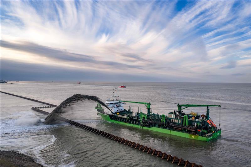 Trailing suction hopper dredger Meuse River rainbowing sand inside the new Cuxhaven berths 5-7 quay line
