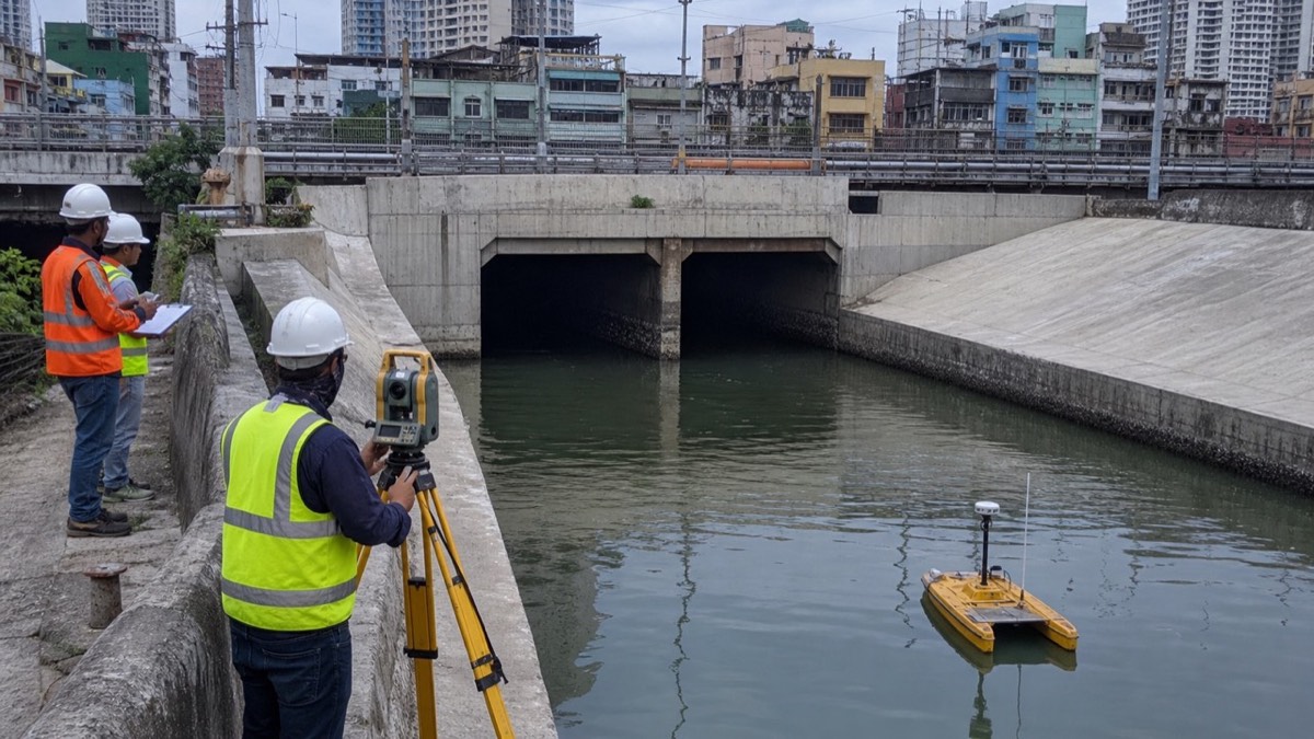 A survey team checking the dredged Libertad Outfall cross-section, sediment records and hydraulic clearance in urban Pasay