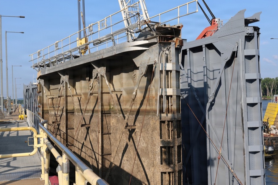 Old and new miter gates at the Lock and Dam 9 replacement workfront during the July 2026 installation