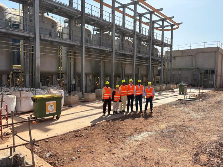 Mamelles project team standing in front of installed process vessels at the desalination plant during a February 2026 visit