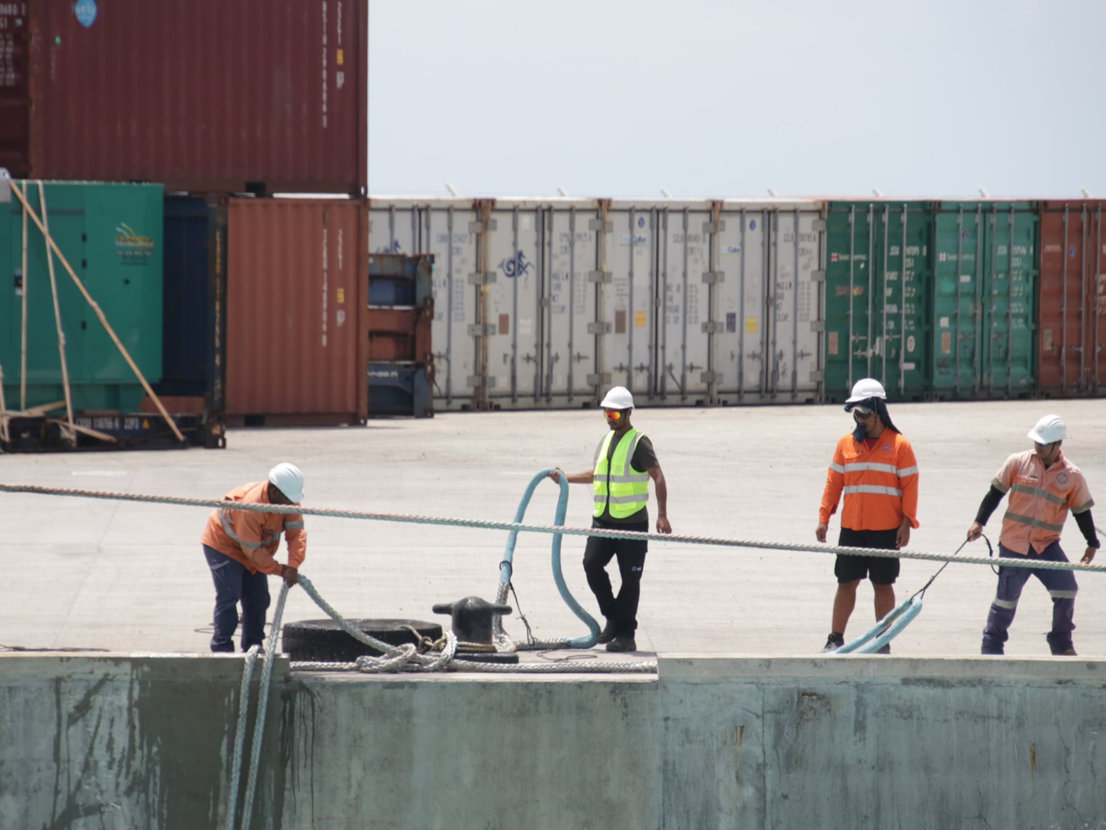 Aiwo Port mooring crew handling lines on the new wharf in front of the operating container yard
