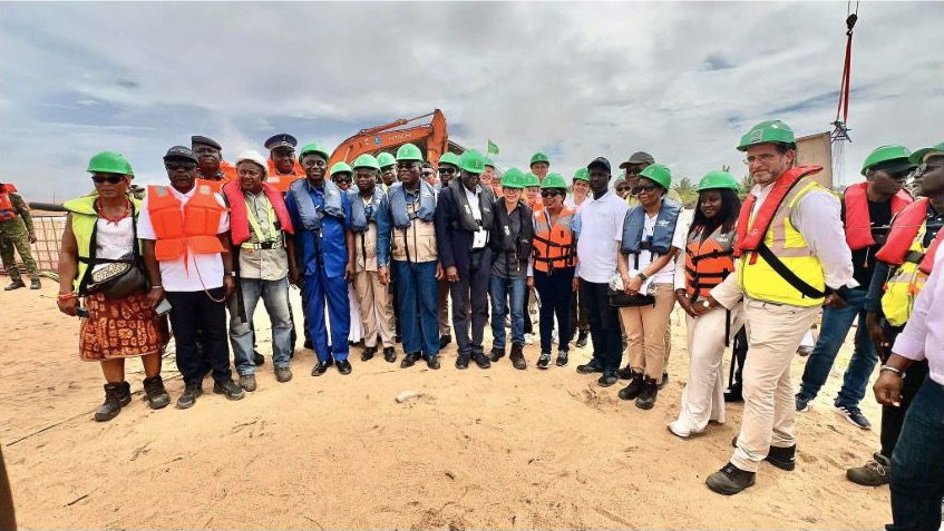 Officials and project staff in safety equipment at the Grand-Lahou coastal-stabilisation work site in Cote d'Ivoire