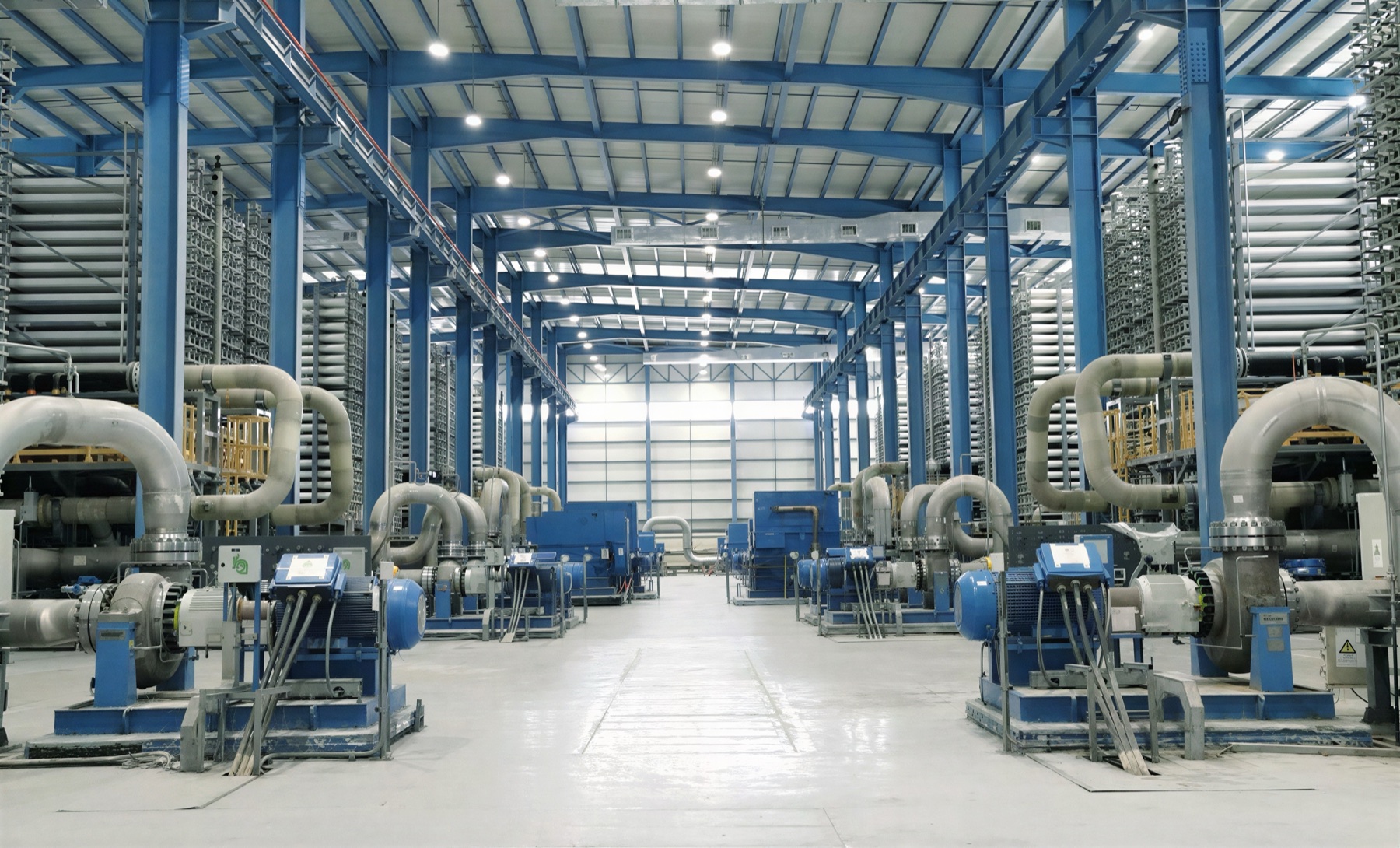 Interior of the Taweelah reverse-osmosis desalination plant showing membrane racks, pumps, and process pipework
