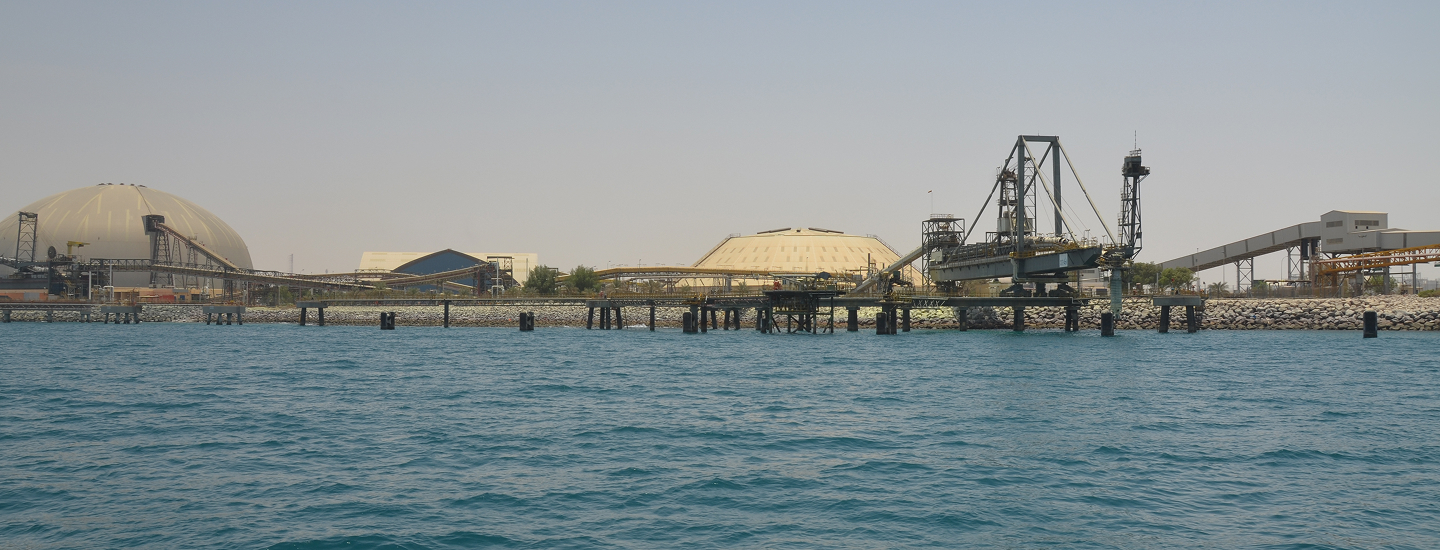 Petroleum terminal waterfront with marine loading structures, conveyors and large storage domes