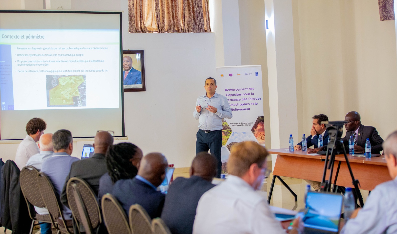 Port engineers and public officials review an aerial plan of Bujumbura Port during the March 2026 climate-resilience workshop