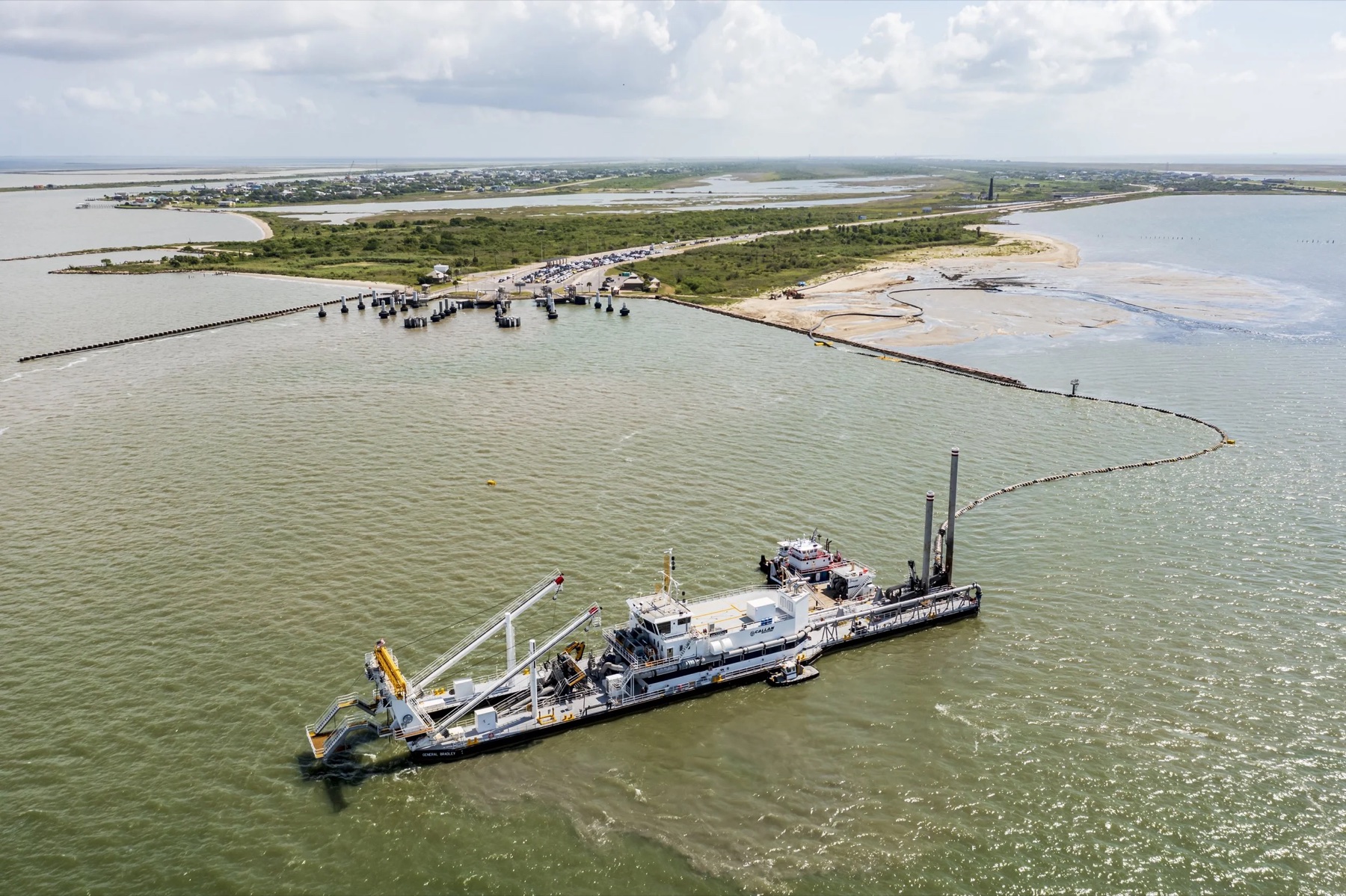 Aerial view of Callan Marine cutter suction dredge General Bradley working beside a floating pipeline and coastal placement area
