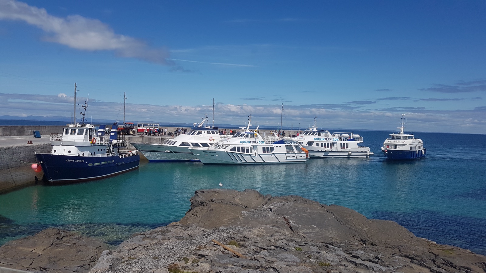 Passenger ferries at the Galway County Council-managed Inis Oirr pier in the Aran Islands, with vessels berthed inside the concrete harbour