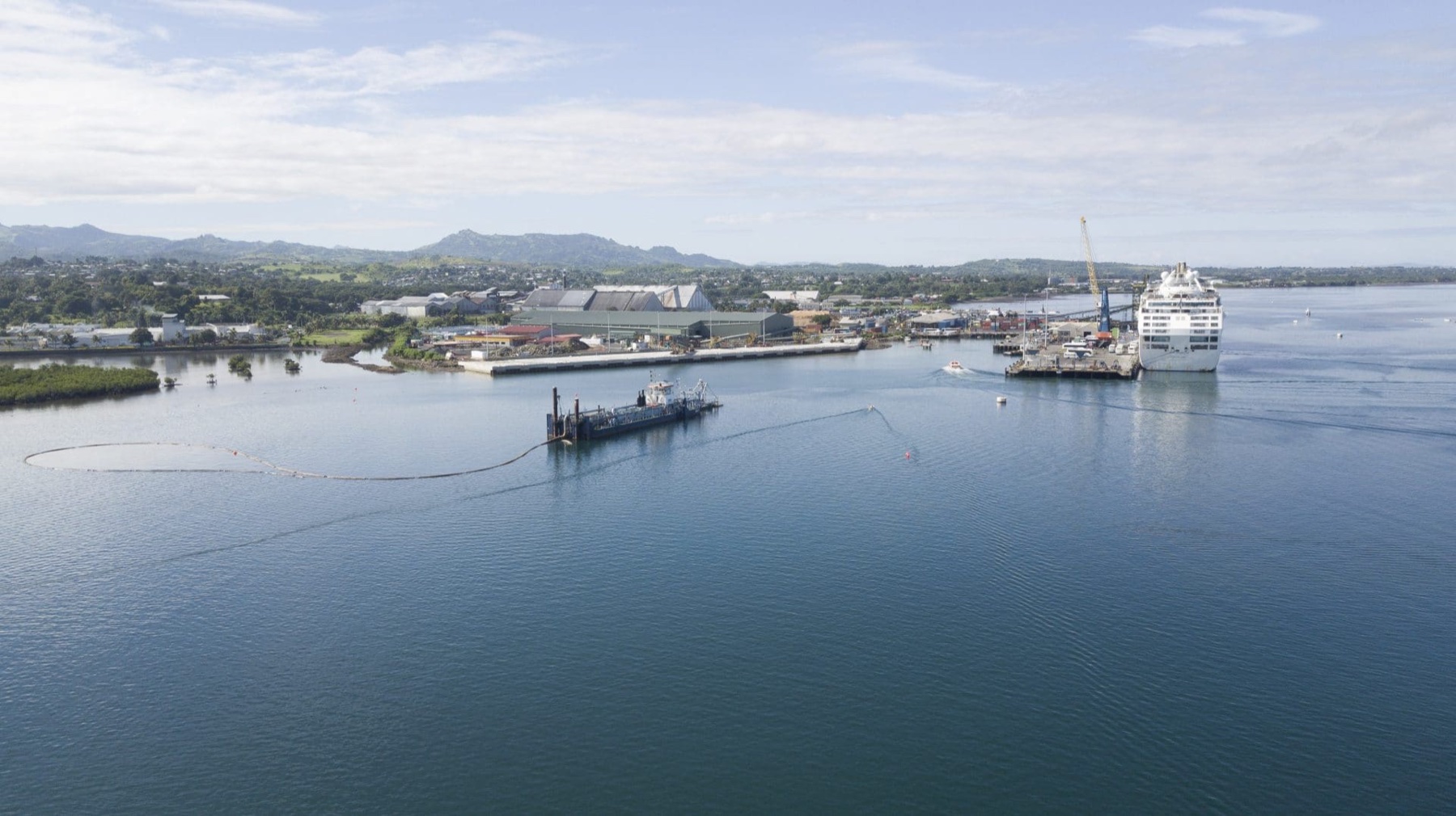 Aerial view of dredging works at Lautoka Wharf, with a dredge and floating pipeline operating inside the port basin