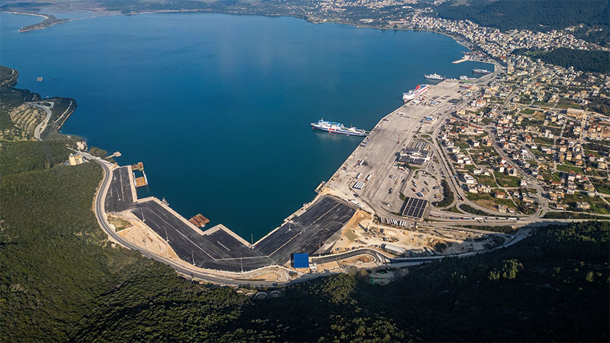 Aerial view across Igoumenitsa Bay showing ferry berths, Ro-Pax vessels, terminal aprons, breakwaters and the city waterfront