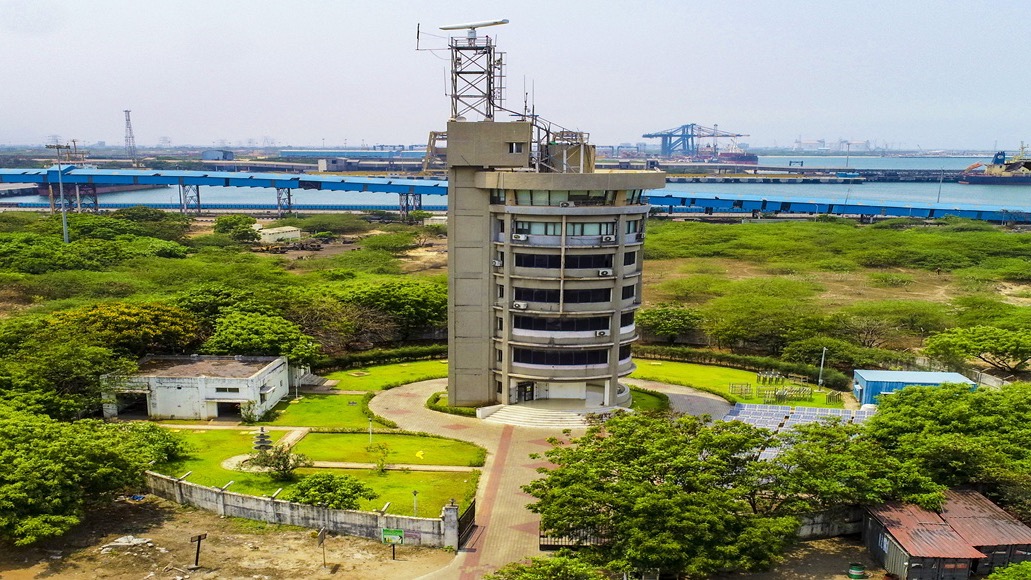 Kamarajar Port marine-services and VTS tower with cargo berths and harbour waters behind