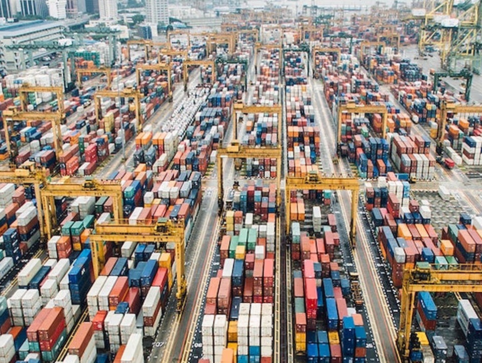 Aerial view of a container terminal yard with dense cargo stacks and rail-mounted gantry cranes