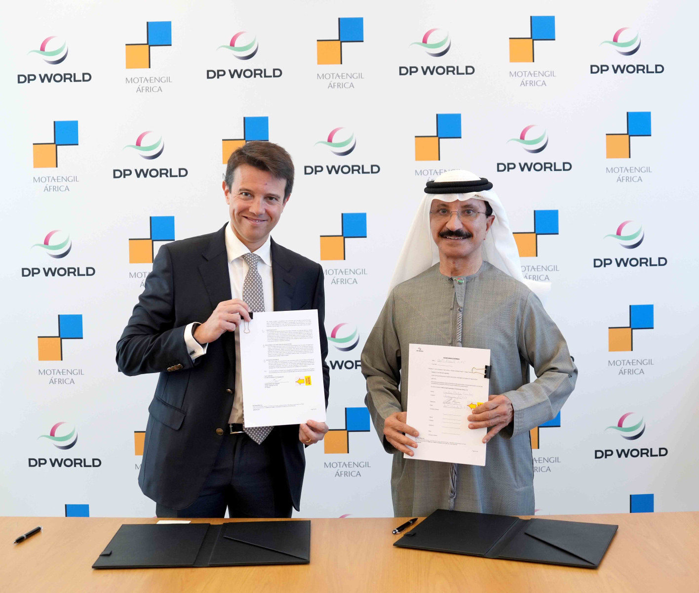 DP World and Mota-Engil executives holding the signed Banana Port phase-one contract documents in March 2025