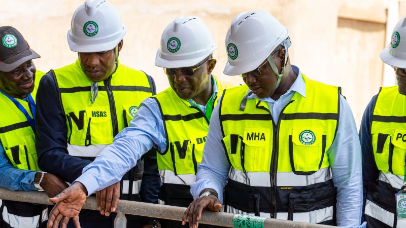 SONES and Senegalese ministry representatives in branded safety equipment reviewing work at the Mamelles desalination plant