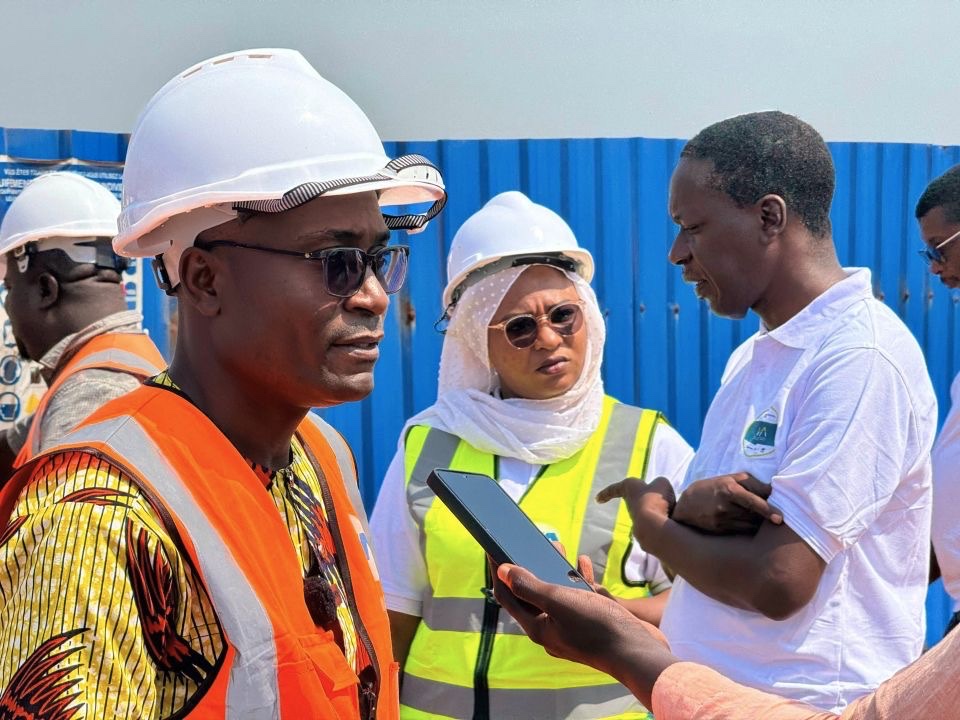 WACA field-mission participants in safety equipment discussing a coastal-resilience work site in Benin
