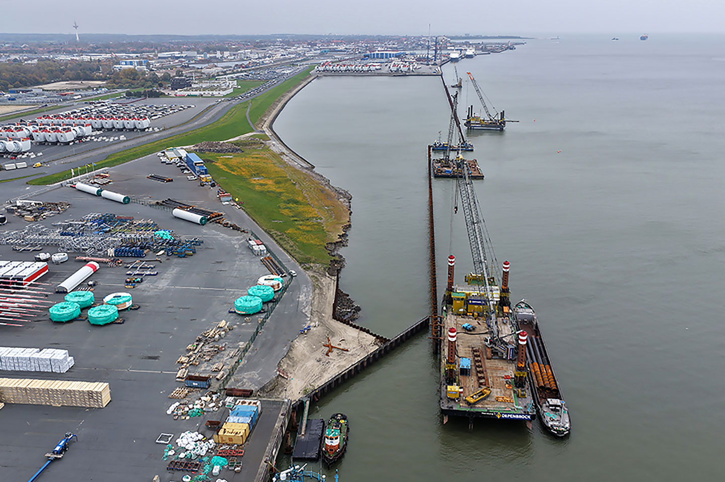 Aerial view of the Cuxhaven berths 5-7 construction site showing the continuous quay pile line and marine piling platforms