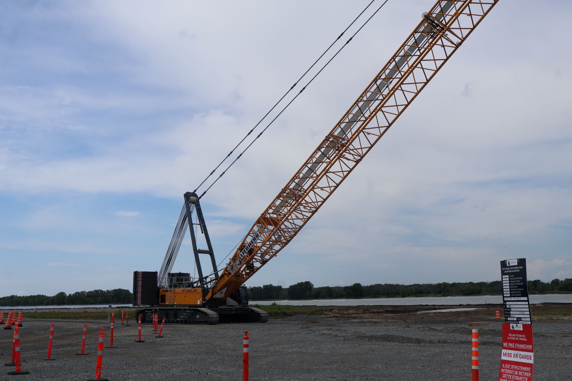 A 300-tonne crawler crane assembled beside the St. Lawrence River at the future Contrecœur container terminal site in June 2026